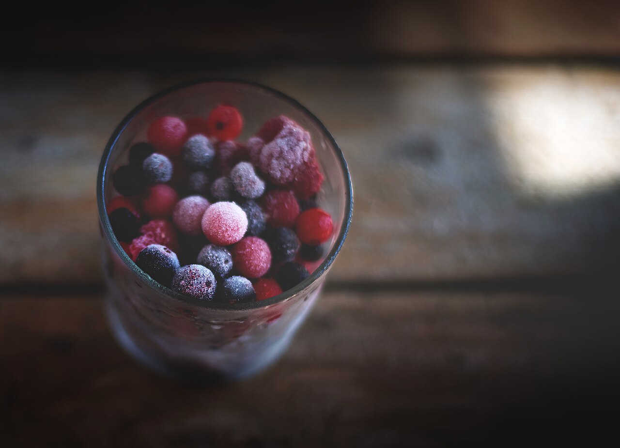 Frozen mixed berries in a glass, frosted with ice