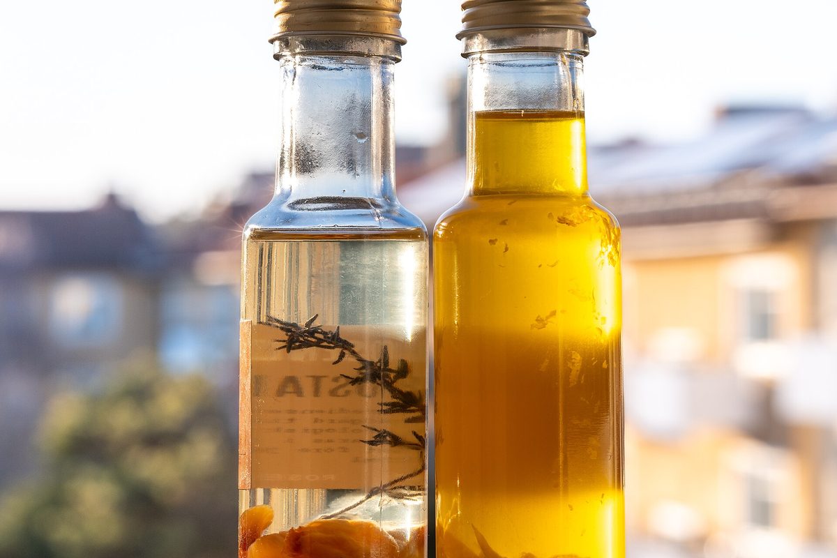 A bottle of garlic-infused olive oil with fresh garlic cloves
