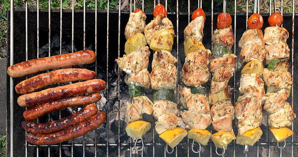 Saucisses et brochettes de poulet sur une grille de barbecue